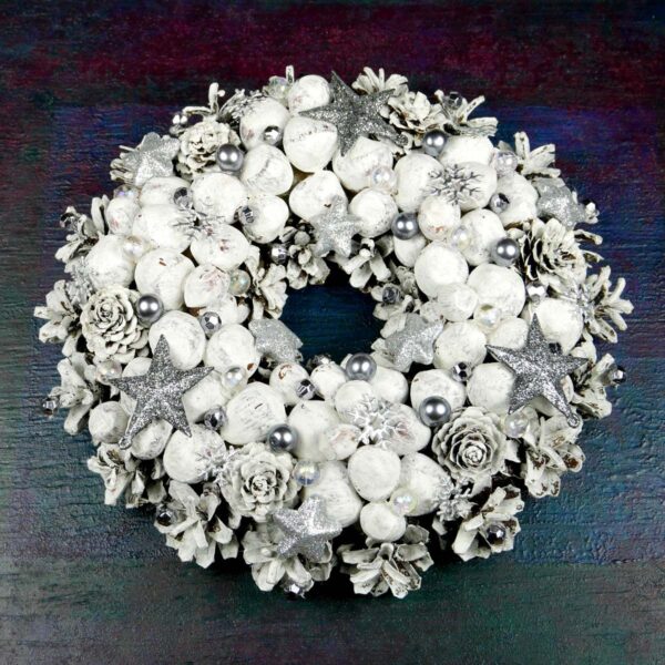 Biały wianek świąteczny z orzechami wykonany na podkładzie słomianym z szyszek, suchych roślin i świątecznych ozdób. Średnica 23 cm.