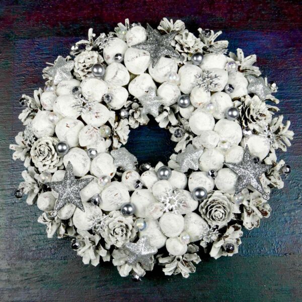 Biały wianek świąteczny z orzechami wykonany na podkładzie słomianym z szyszek, suchych roślin i świątecznych ozdób. Średnica 23 cm.
