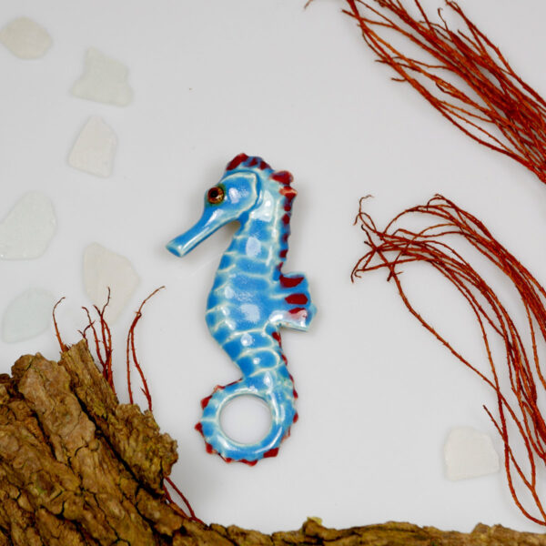 Ceramiczny konik morski błękitny. Dekoracja marynistyczna do powieszenia na ścianę, wykonana ręcznie z gliny, wypalana i szkliwiona.